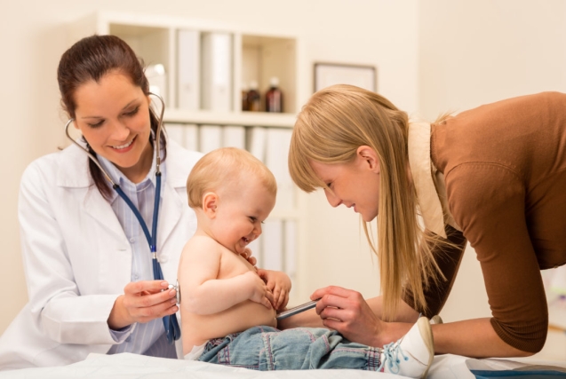 Female pediatrician checking cute baby girl with stethoscope mother assistance